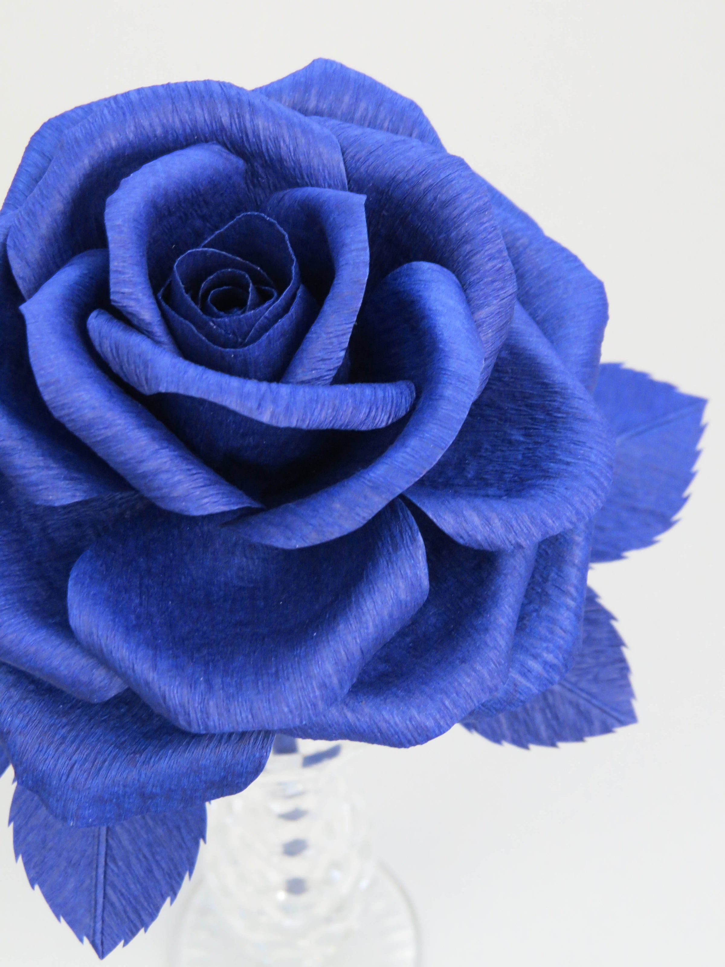 Close up detail of the texture on the petals of a sapphire blue crepe paper rose