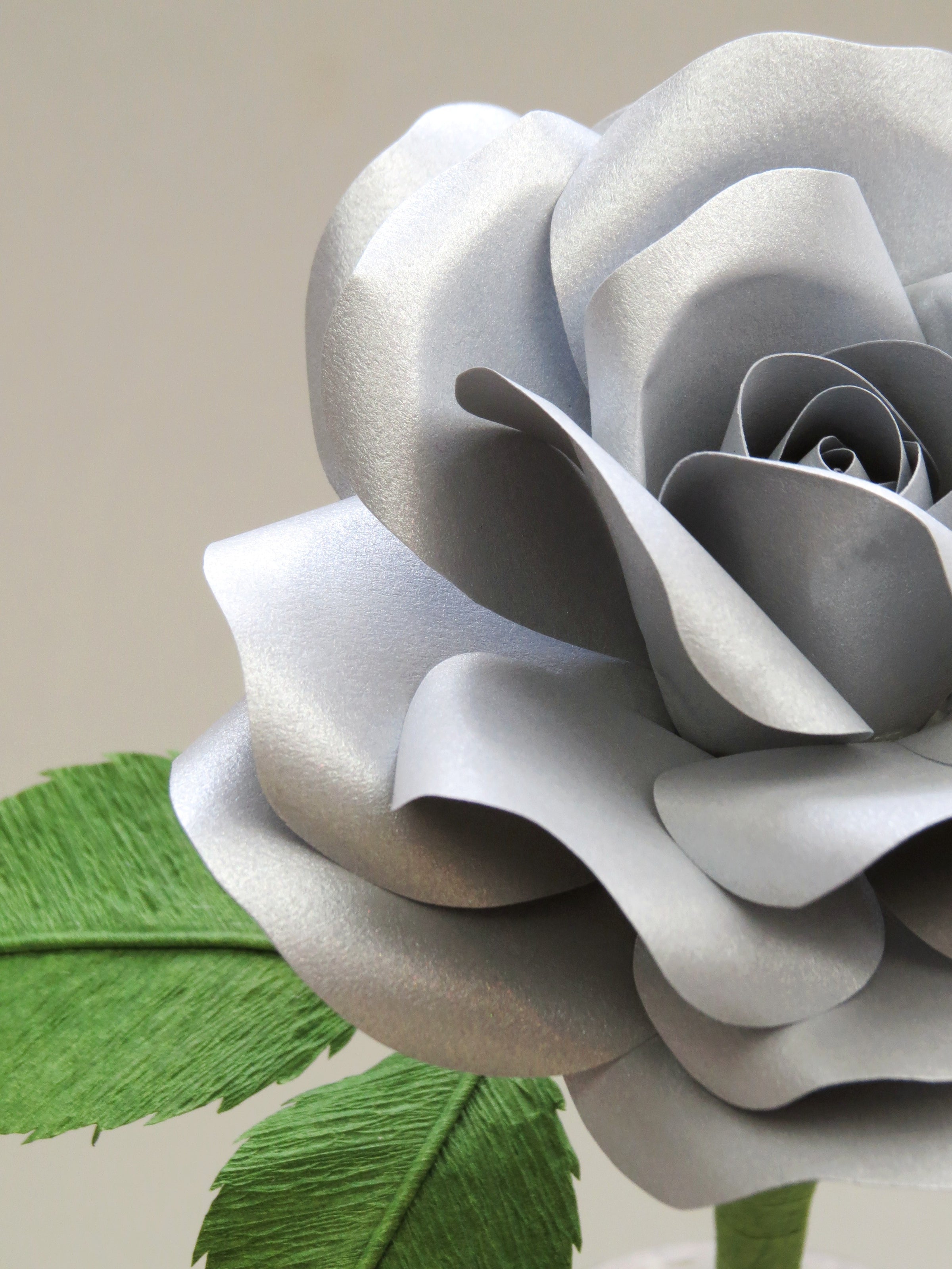 Close up detail of the texture on the petals of a metallic steel paper rose
