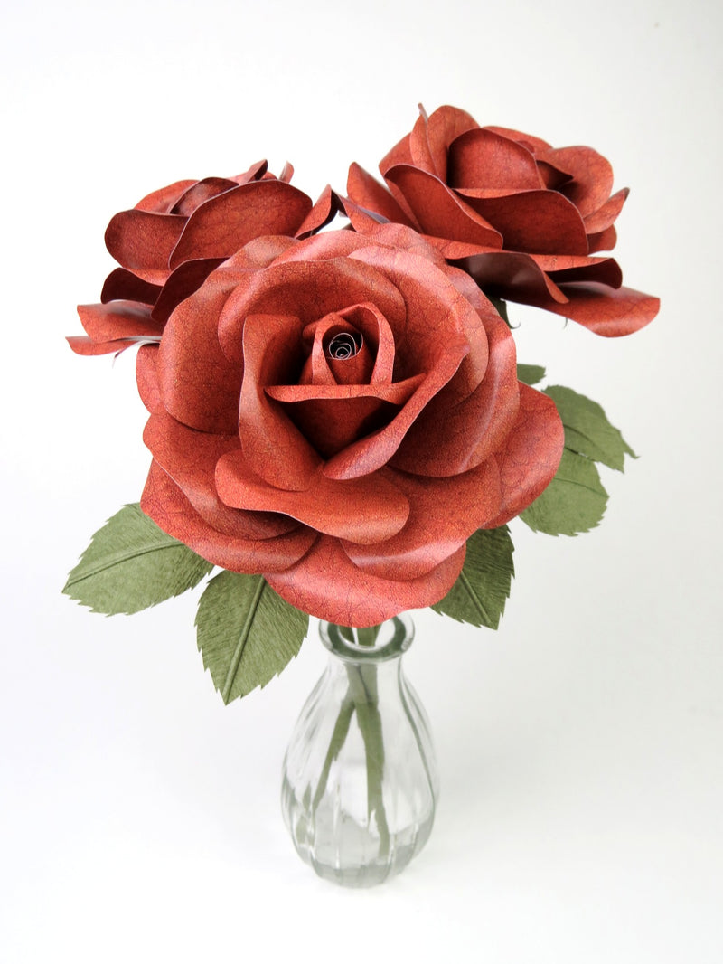 Bouquet of three brown leather grain paper roses in a glass vase