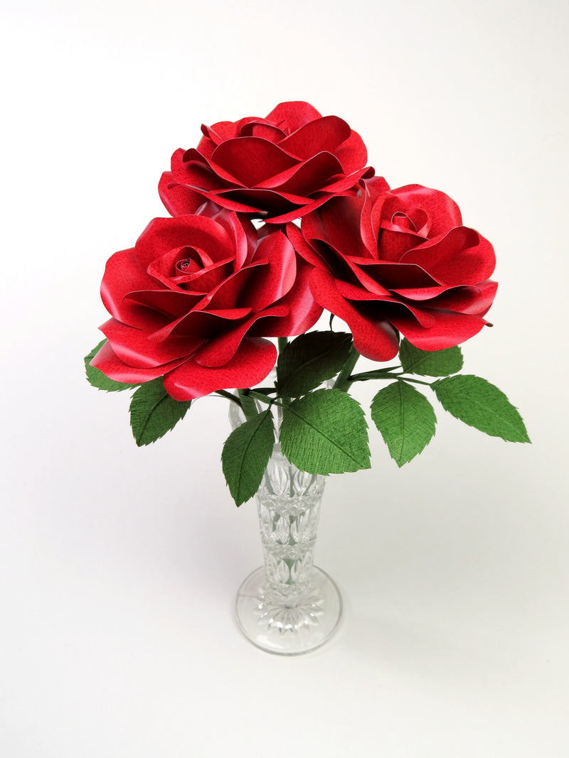 Bouquet of three red leather grain paper roses sitting in a crystal vases 